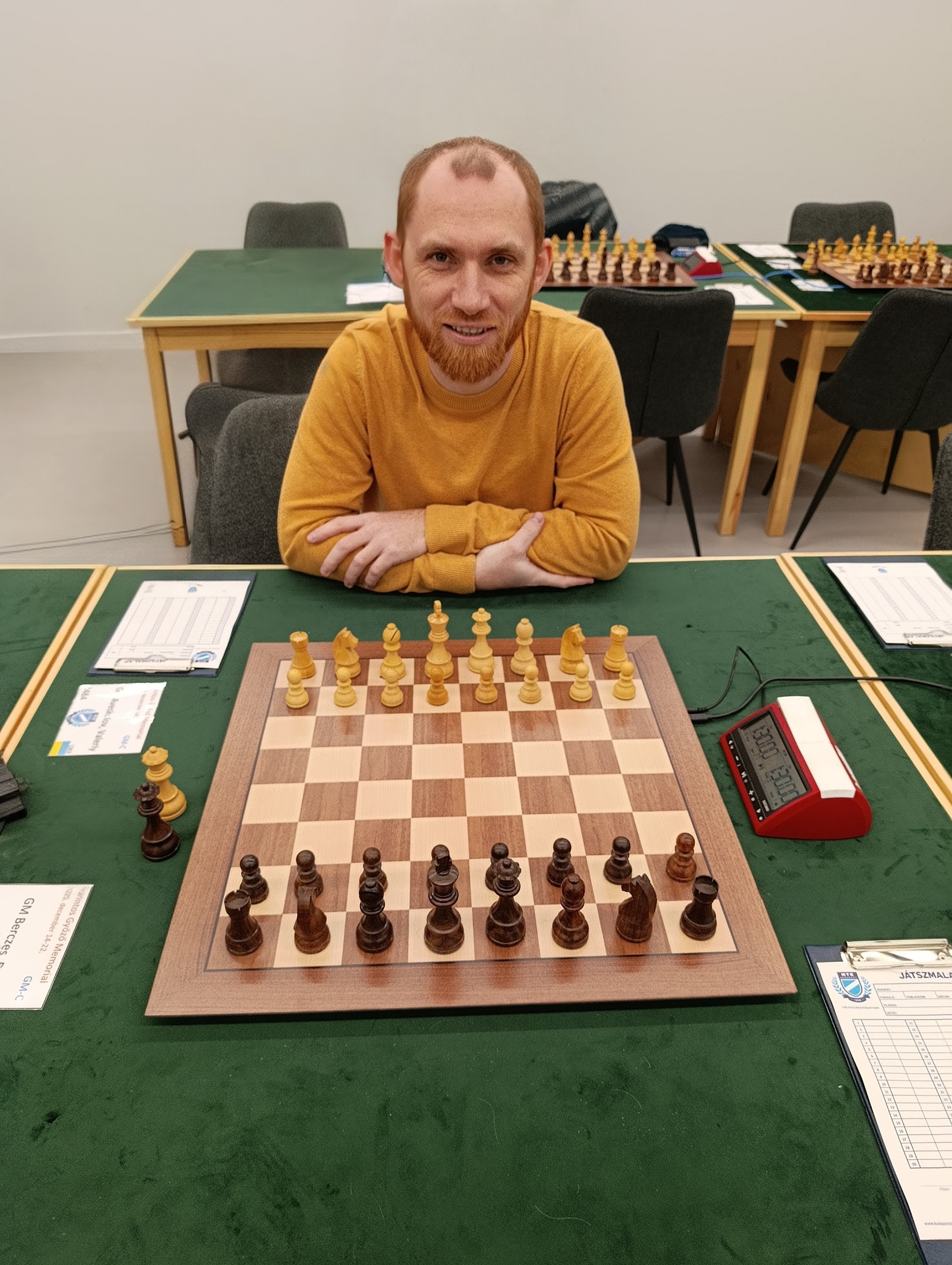 Valeriy Aveskulov seated behind a chessboard in a training room.