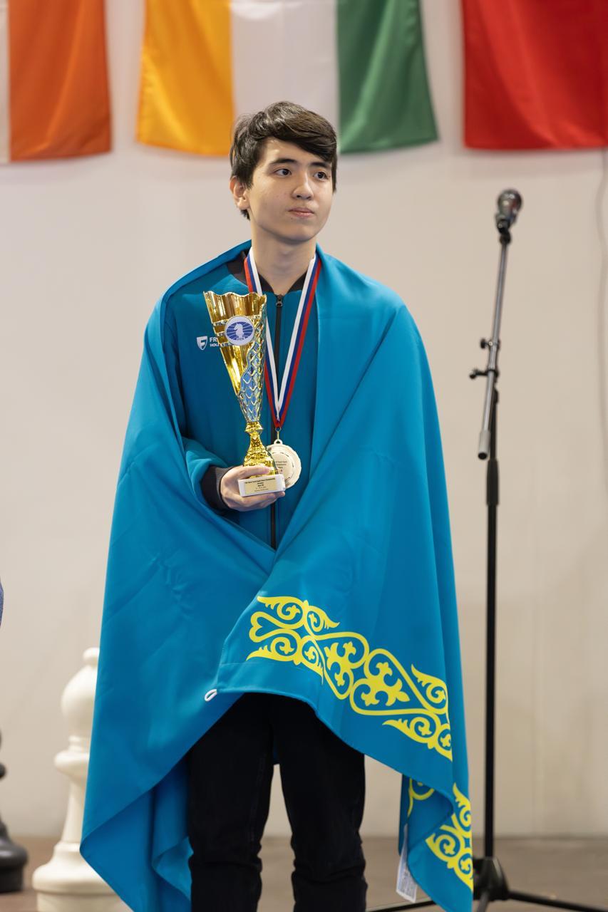 Miras Assylov with a trophy and medal.